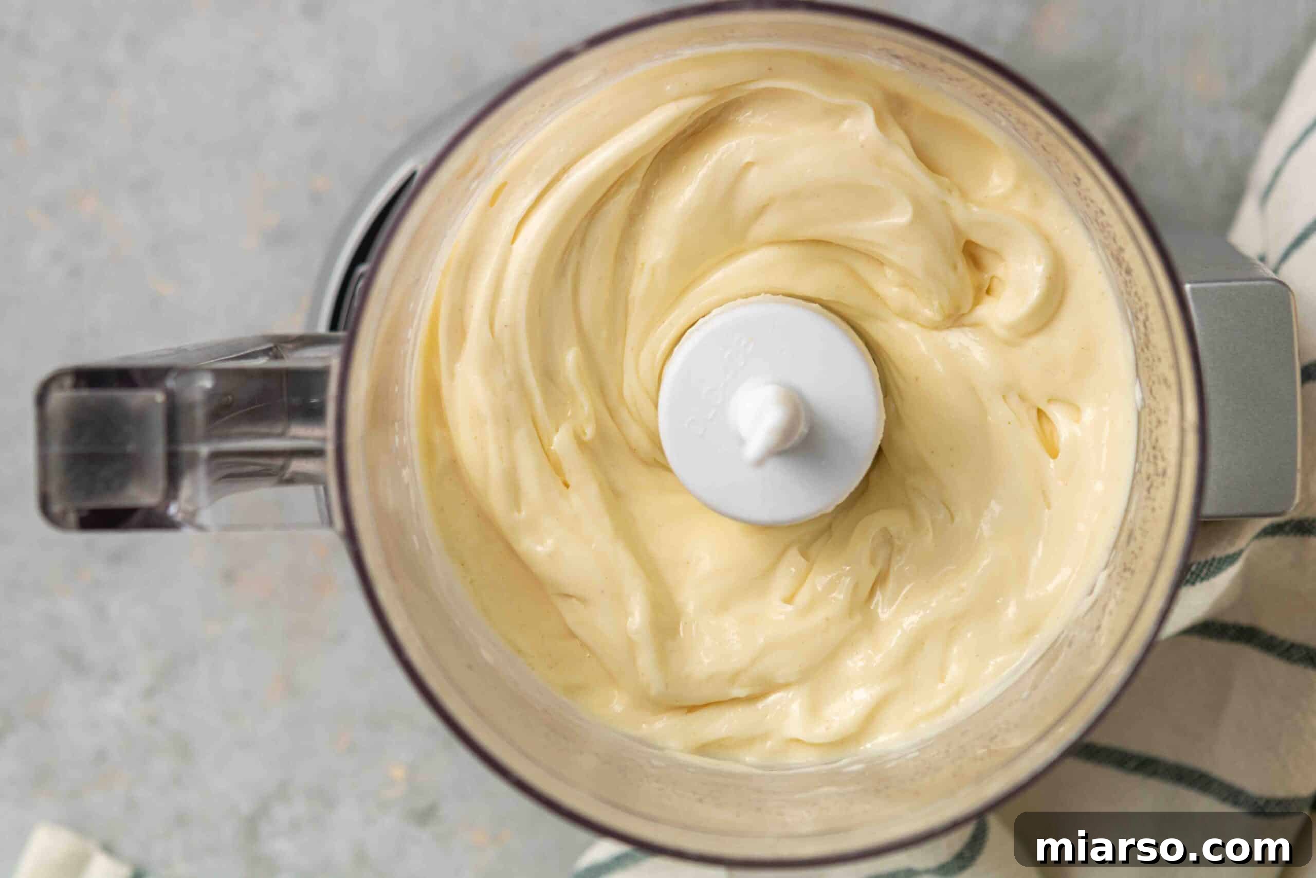 Overhead shot showcasing the beautiful, thick texture of homemade mayo in a bowl.