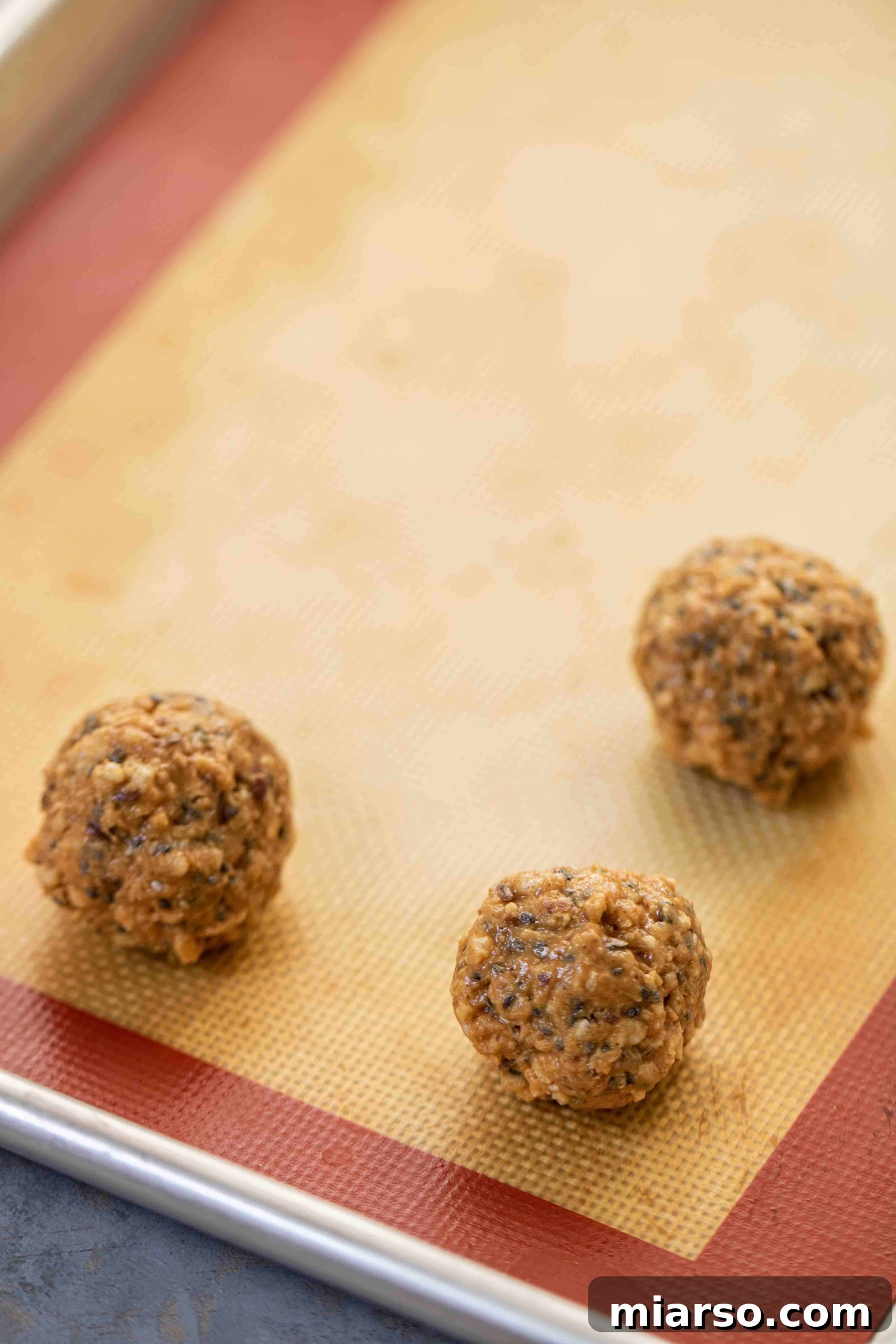 Tray of rolled chia seed peanut butter balls ready for freezing.
