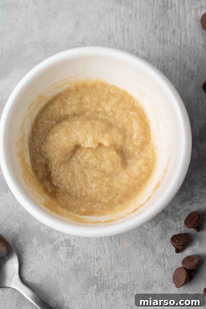 Adding almond flour, baking powder, salt, and chocolate chips to the wet ingredients.