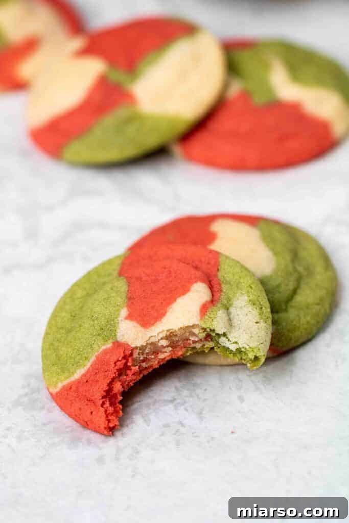 Christmas sugar cookie with a bite taken out of it, showcasing the marbled red, white, and green interior.