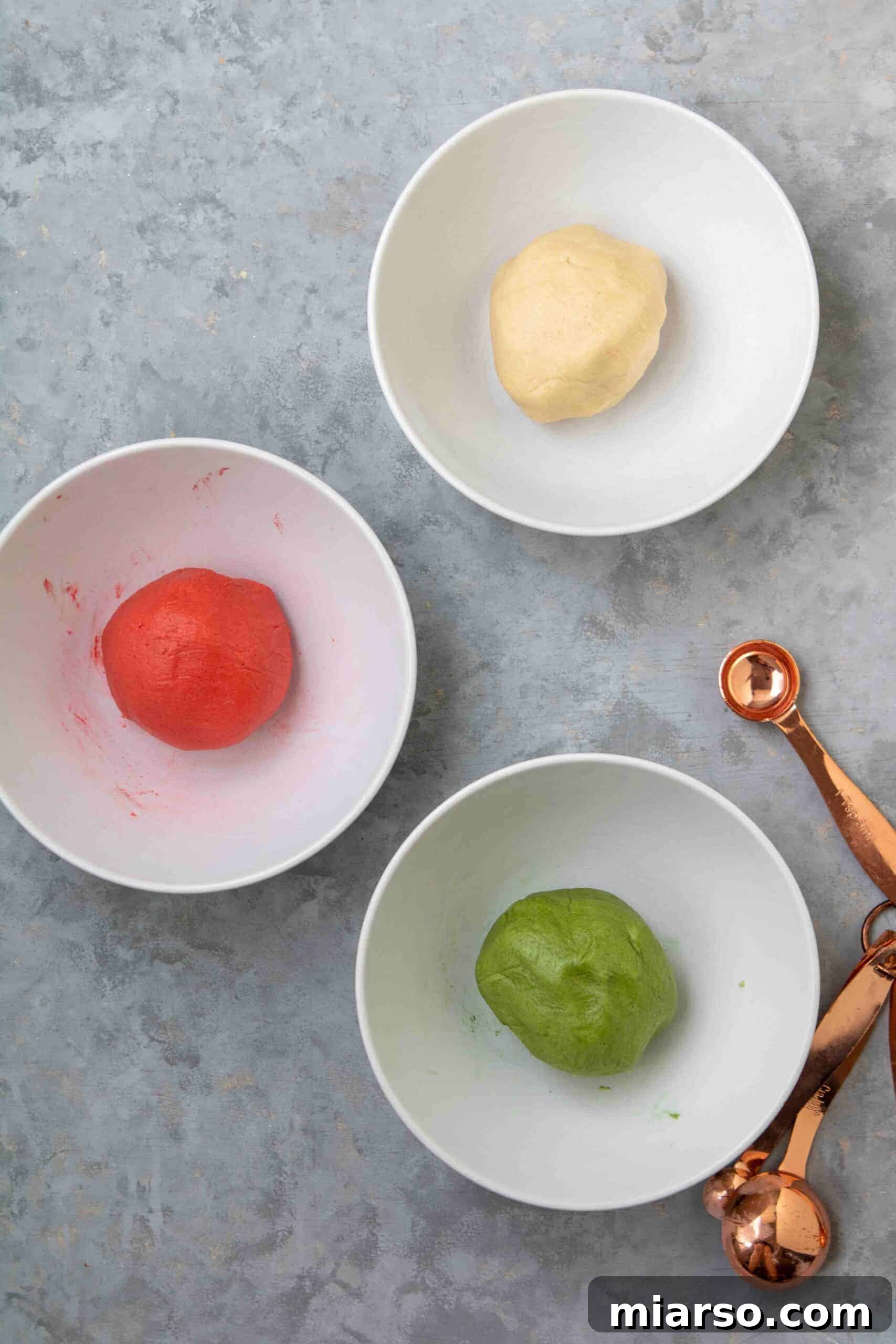 Dough separated into three bowls: one red, one green, one white