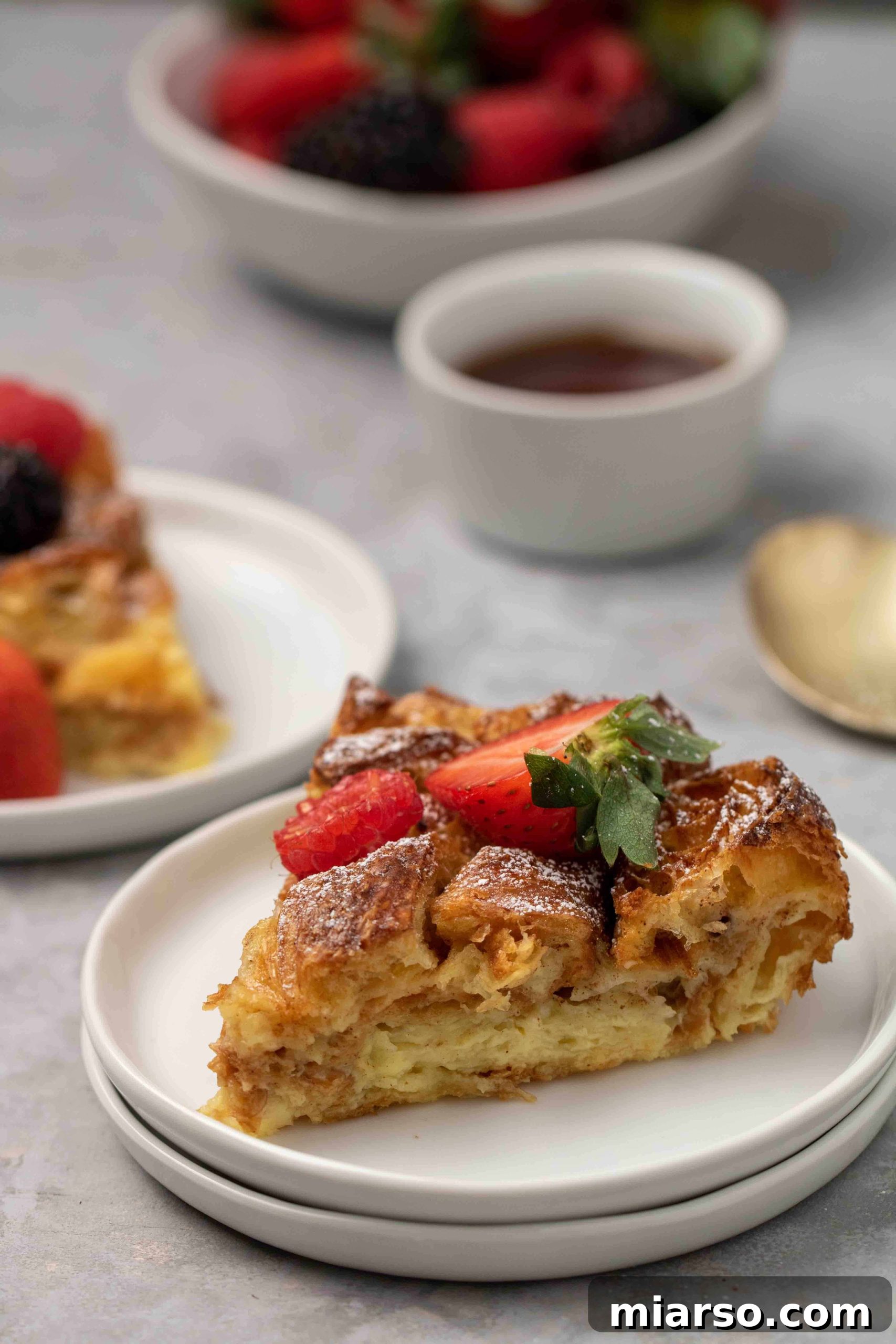 Heavenly Croissant French Toast Bake 14 Two generous slices of Croissant French toast bake, showing the custardy interior and golden crust, on a white plate.