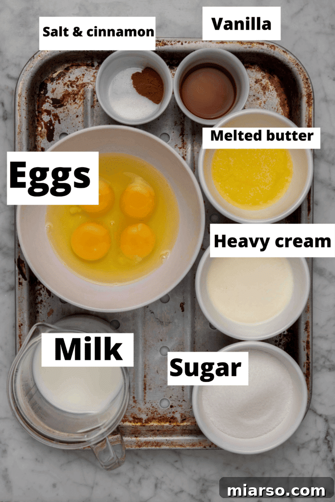 Heavenly Croissant French Toast Bake 3 A collection of ingredients for Croissant French toast bake, including fresh eggs, a carton of milk and heavy cream, a bowl of sugar, and melted butter, carefully arranged on a wooden surface.