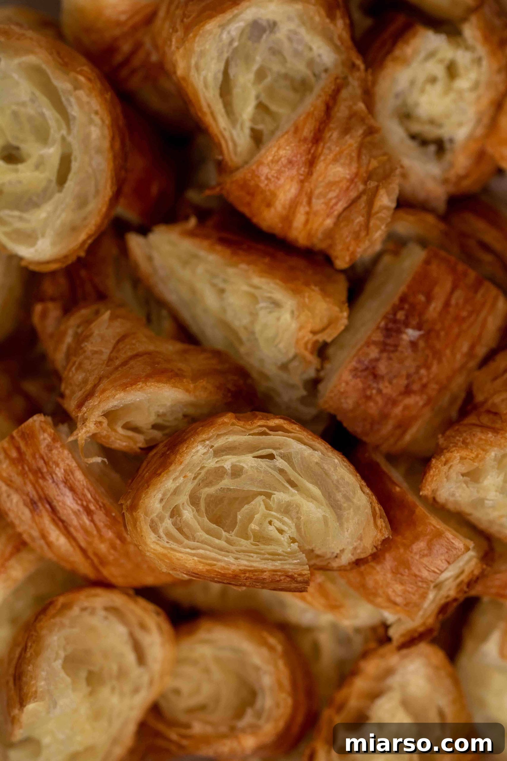 Heavenly Croissant French Toast Bake 5 Close-up of torn day-old croissants ready for the French toast bake, showing their flaky layers.