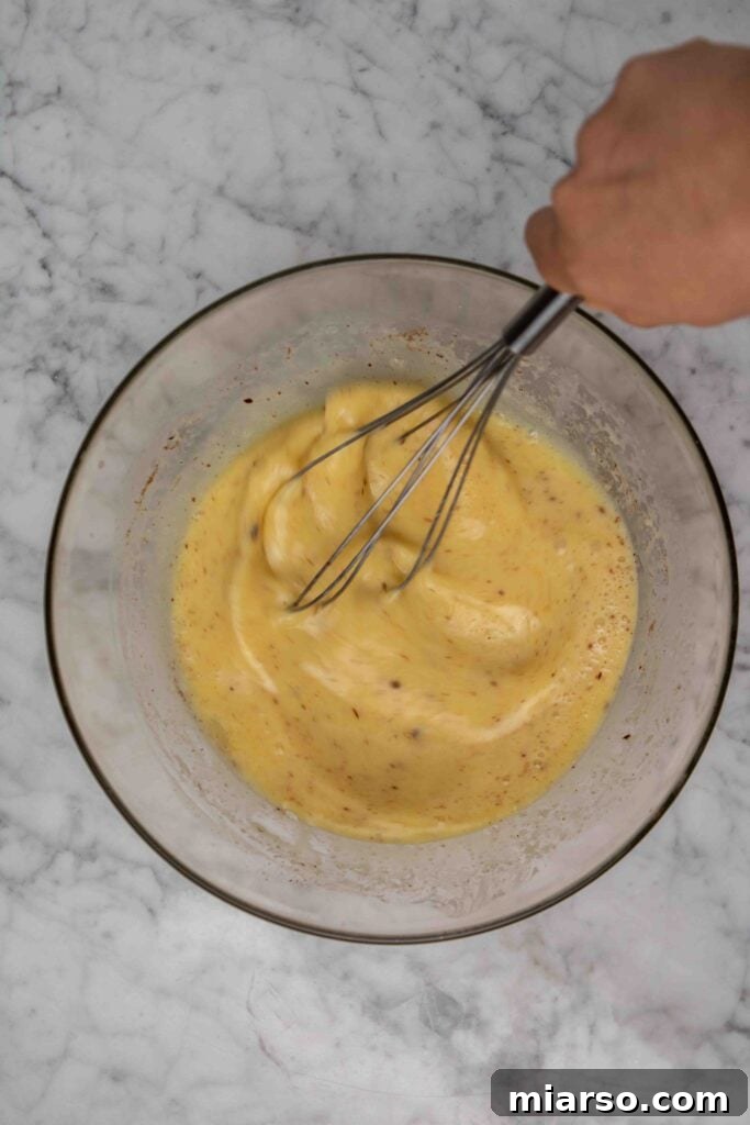 Heavenly Croissant French Toast Bake 7 A bowl filled with a whisked egg custard mixture for French toast, ready for the croissants.