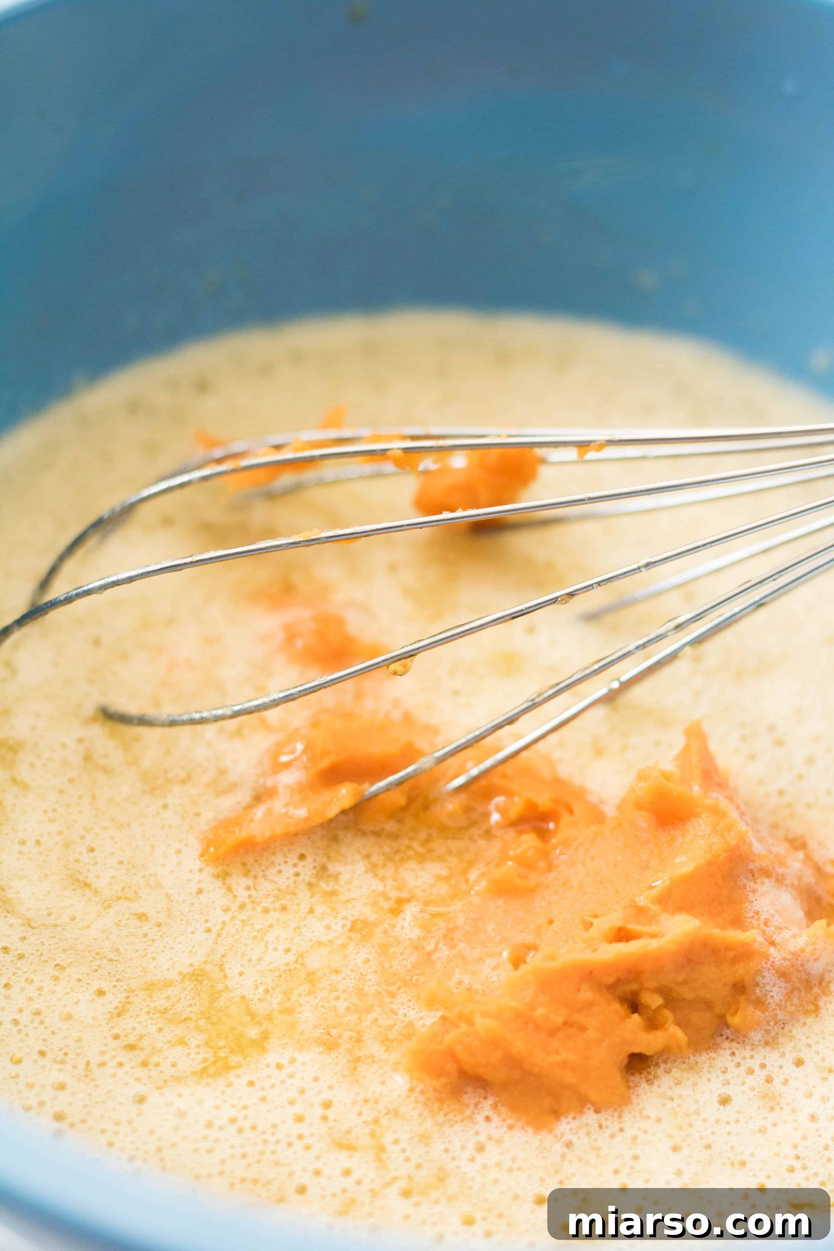 Mixing sweet potato puree and oils into brownie batter