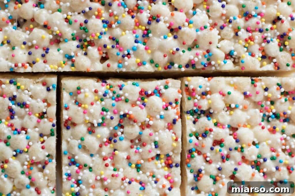 A stack of Quinoa Pop Krispie Treats with sprinkles on a wooden board