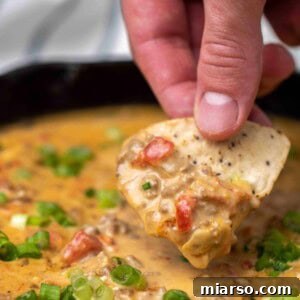 Rotel dip bite with a chip, showing the creamy texture.