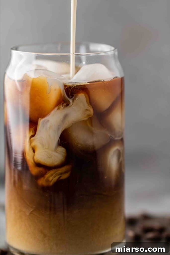 Starbucks Velvety Vanilla Cold Brew 2 Close-up of a glass of Starbucks vanilla sweet cream cold brew with cream swirls, showing a refreshing iced coffee drink.