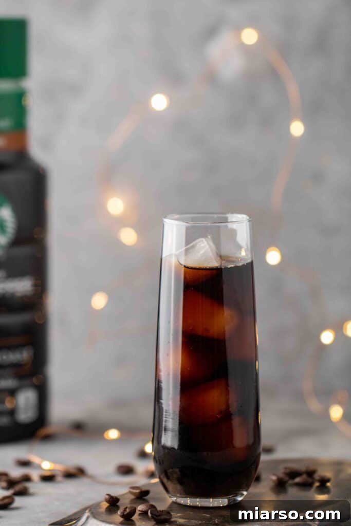 Starbucks Velvety Vanilla Cold Brew 12 Tall glass of iced coffee with a straw, showing the inviting appearance of a cold brew.