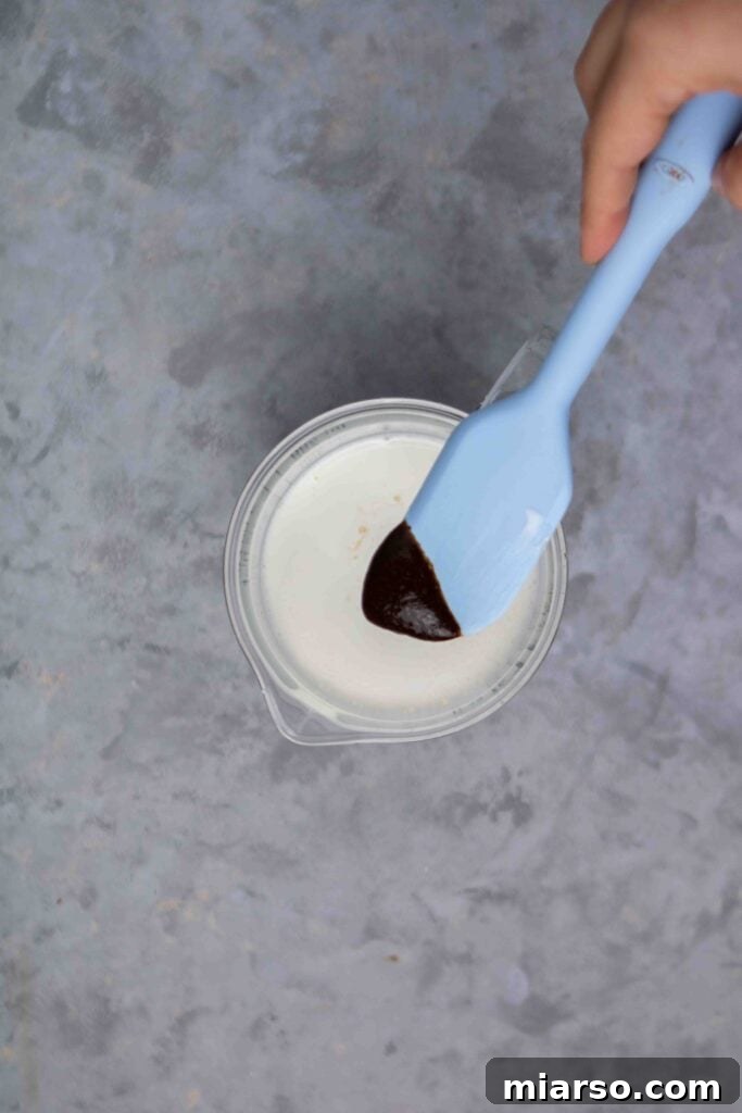 Starbucks Velvety Vanilla Cold Brew 10 A whisk blending all the sweet cream ingredients in a bowl, showing a smooth mixture forming.