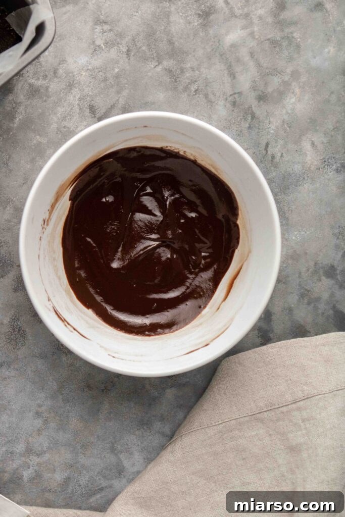 Step-by-step guide: Stirring the vegan chocolate ganache to a smooth consistency.