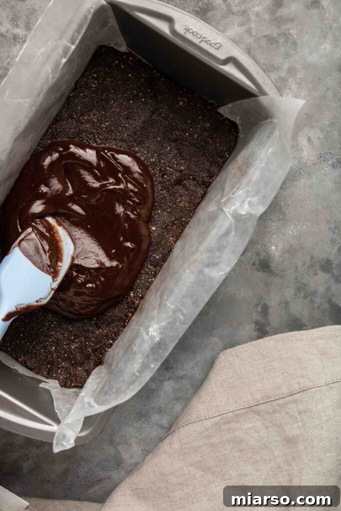Step-by-step guide: Adding cocoa butter and maple syrup to the hazelnut mixture.