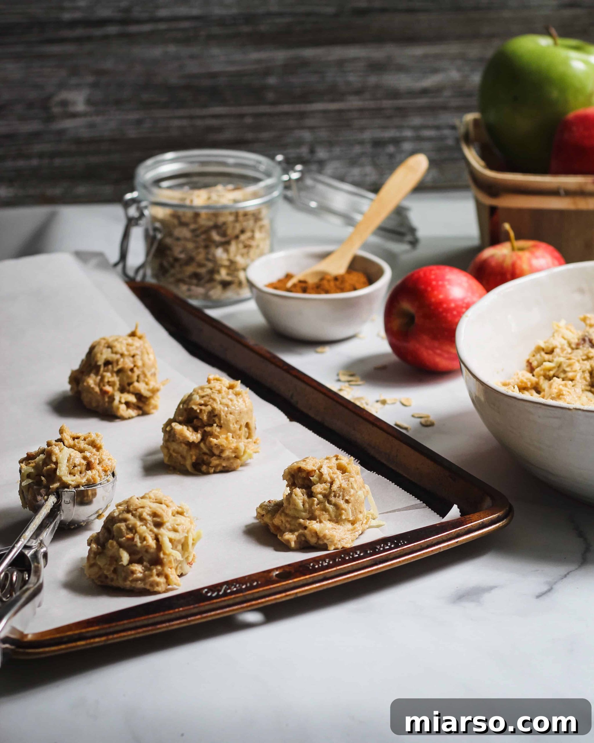 Cozy Apple Cinnamon Oat Cookies 3 Close-up of Apple Cinnamon Oatmeal Cookies, showing their golden brown edges and chewy interior with visible oats and apple pieces.