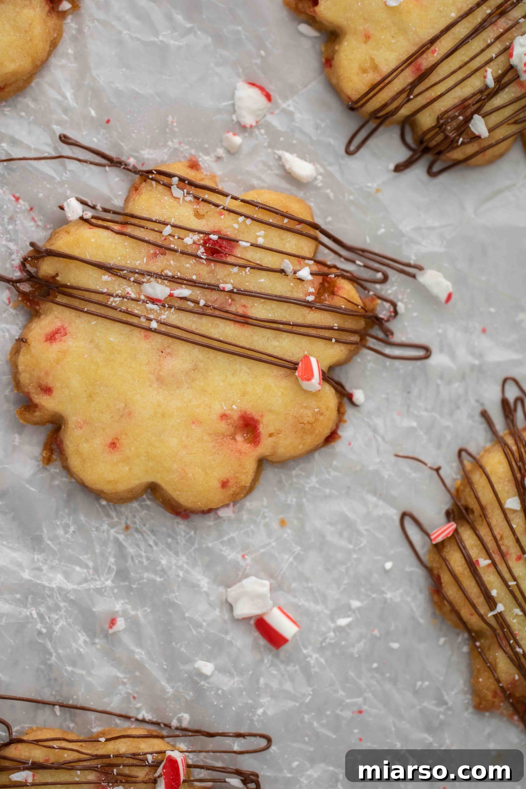 Overhead shot of the ingredients for peppermint shortbread cookies laid out, including flour, butter, sugar, egg yolk, and candy canes.