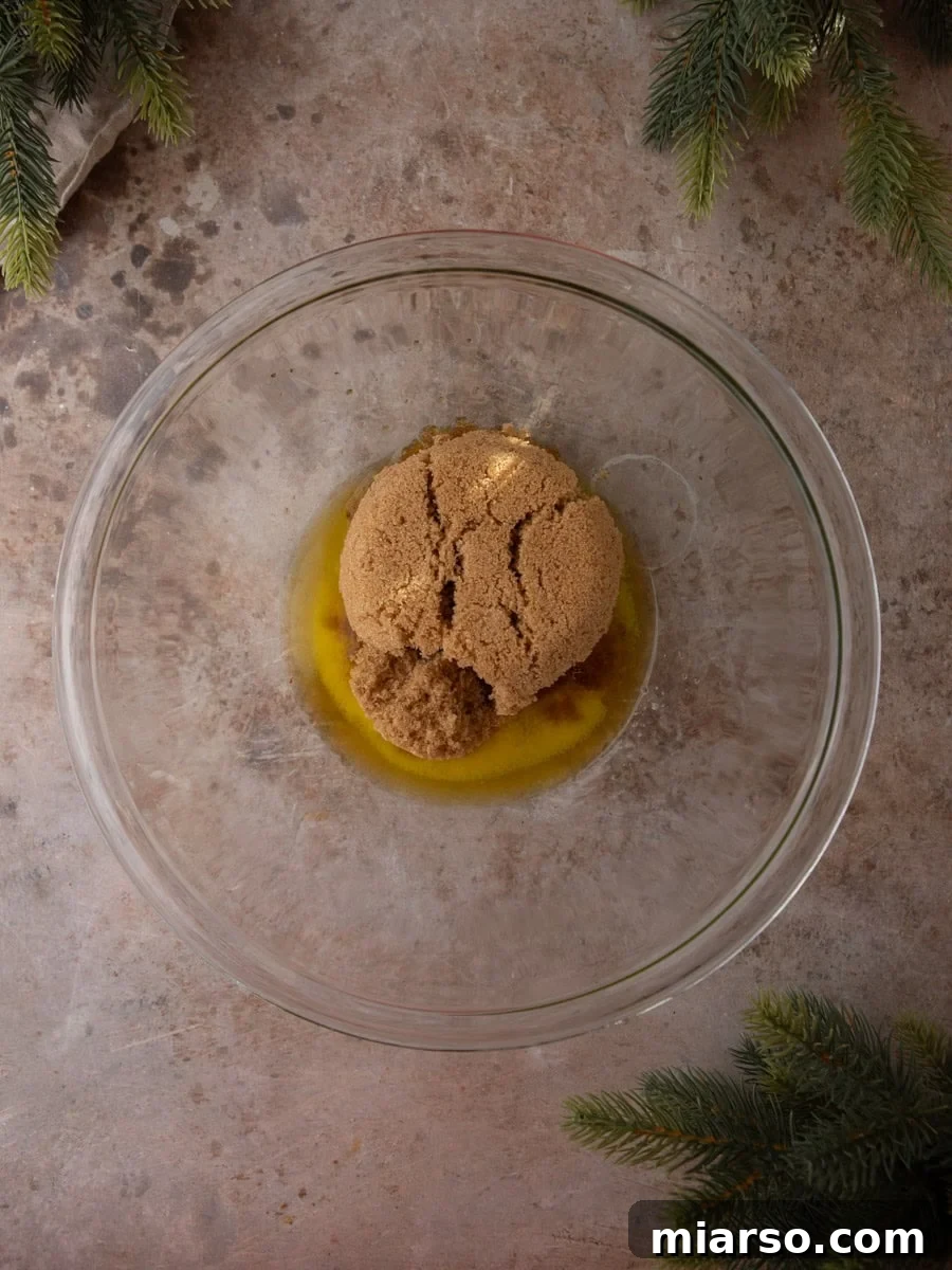 Melted butter and packed brown sugar in a glass mixing bowl before combining.
