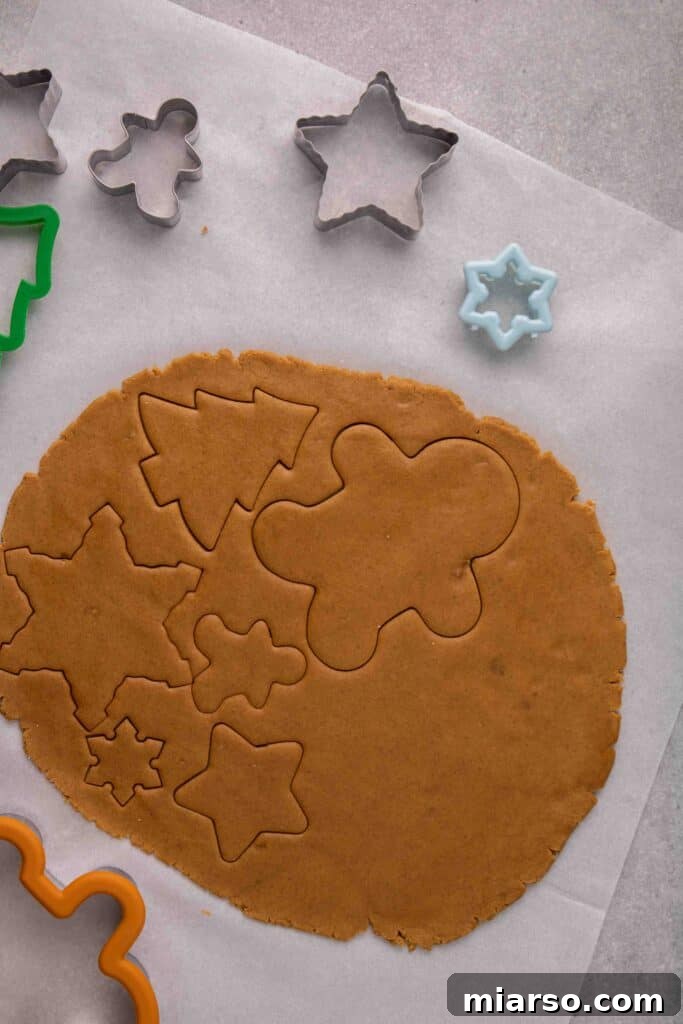 Various cutout gingerbread cookies on baking sheet