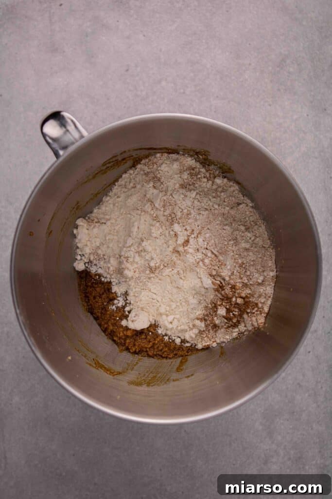 Adding dry ingredients to the wet mixture for gingerbread