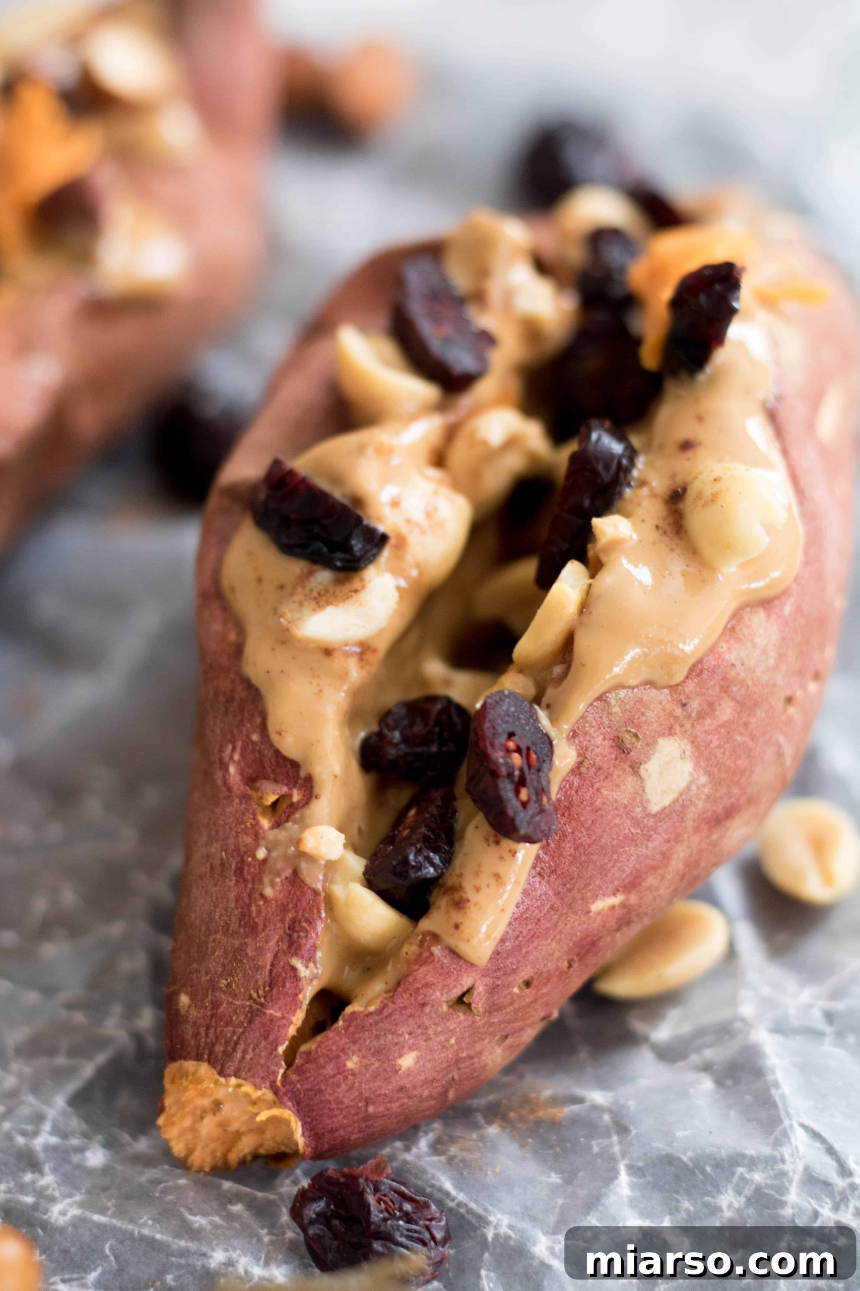 Close-up shot of a deliciously stuffed sweet potato breakfast, garnished with nuts and cranberries, ready to eat.