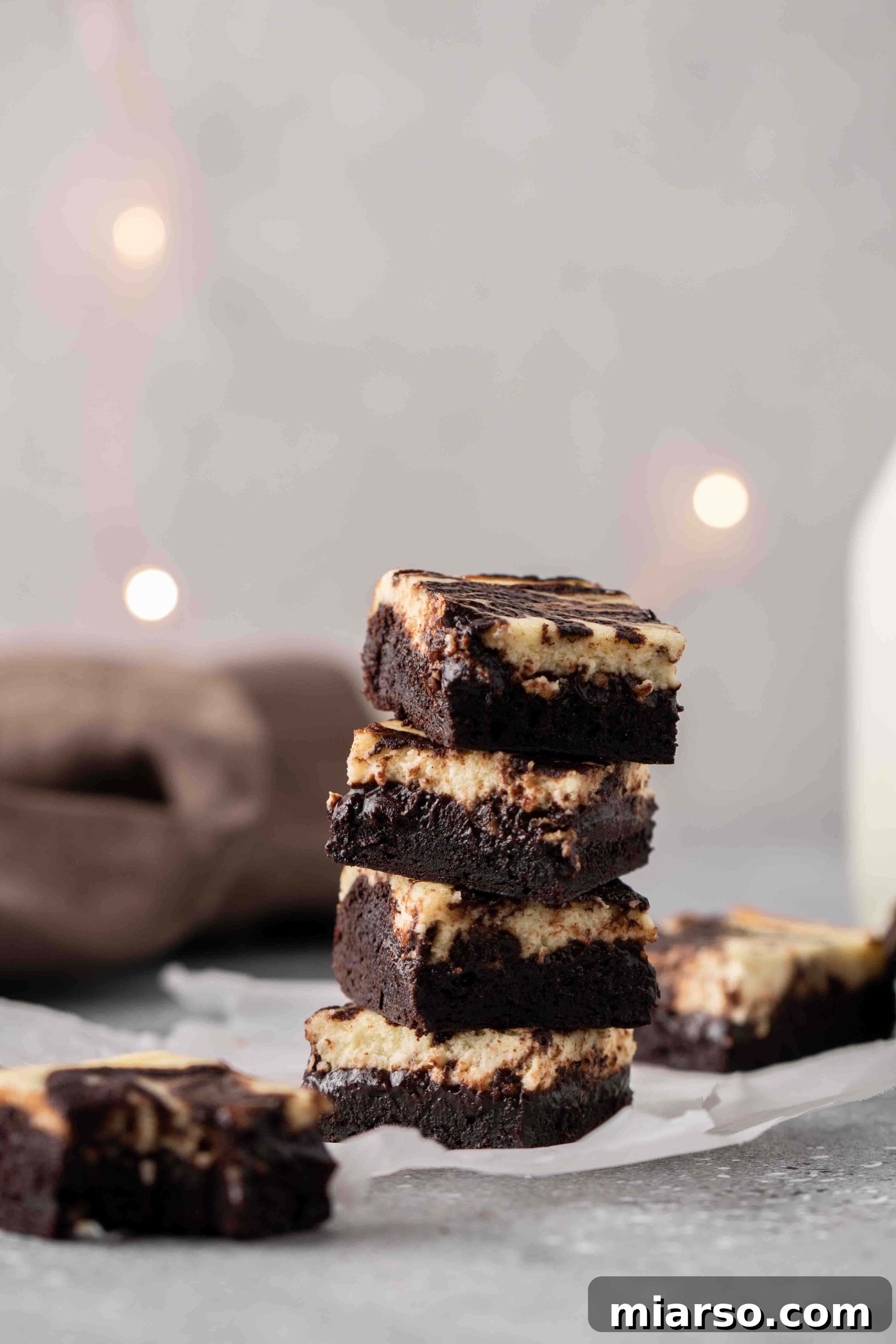 Stack of perfectly chewy cream cheese brownies with rich chocolate and creamy swirls