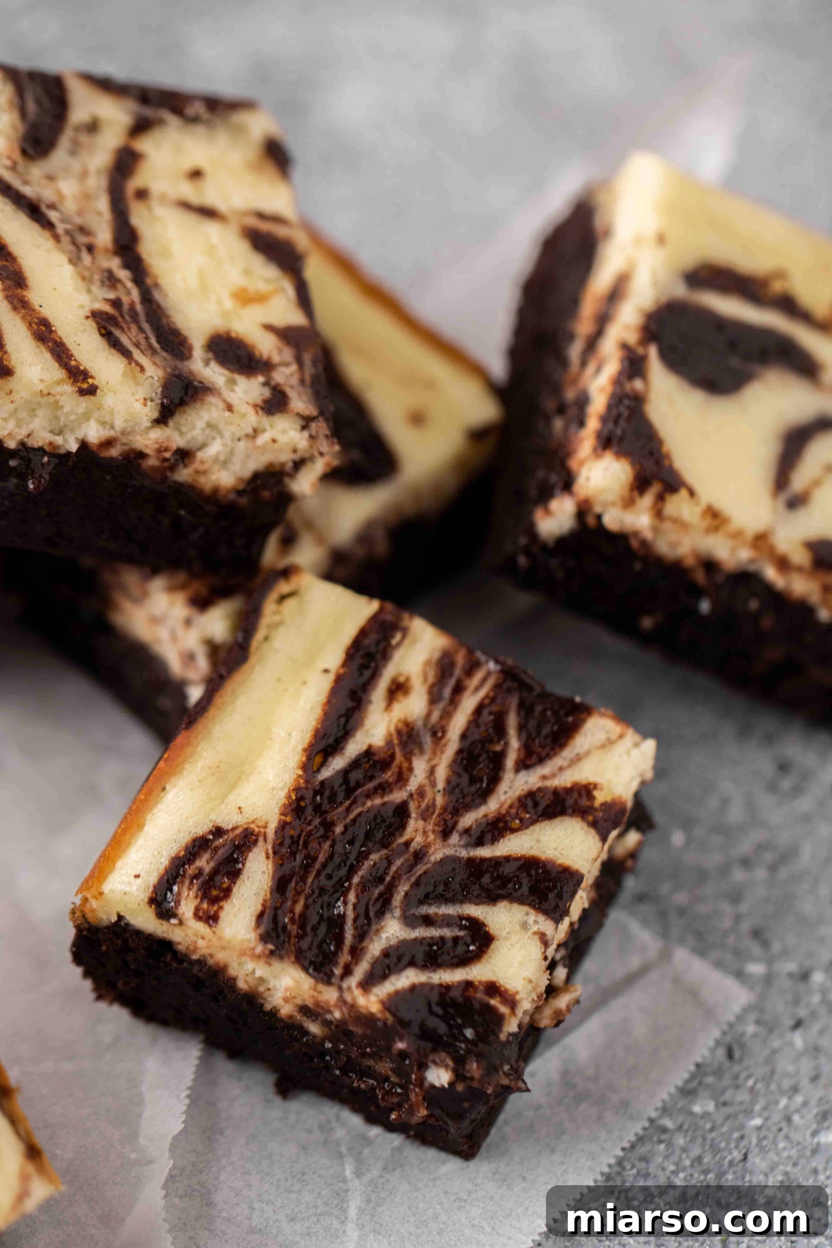 Close up of a perfectly cut cream cheese brownie, showing the distinct layers