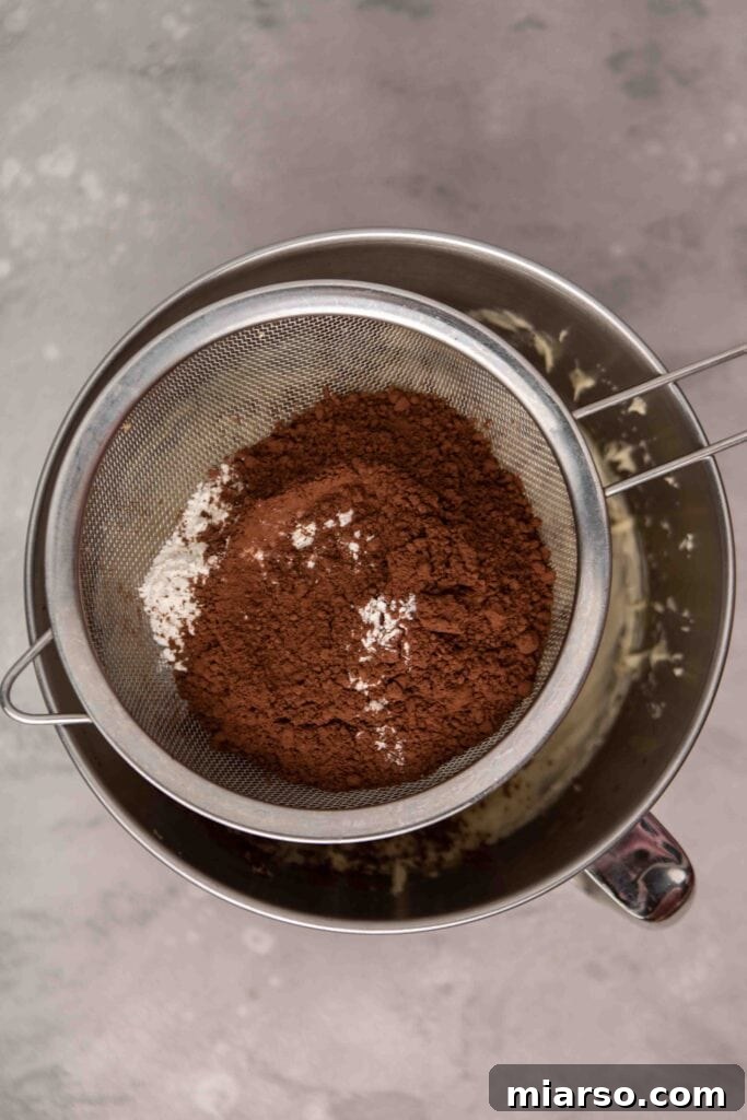 Sifting cocoa powder and flour into brownie wet ingredients