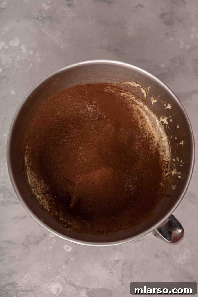 Sifting cocoa powder and flour into the wet ingredients for brownies