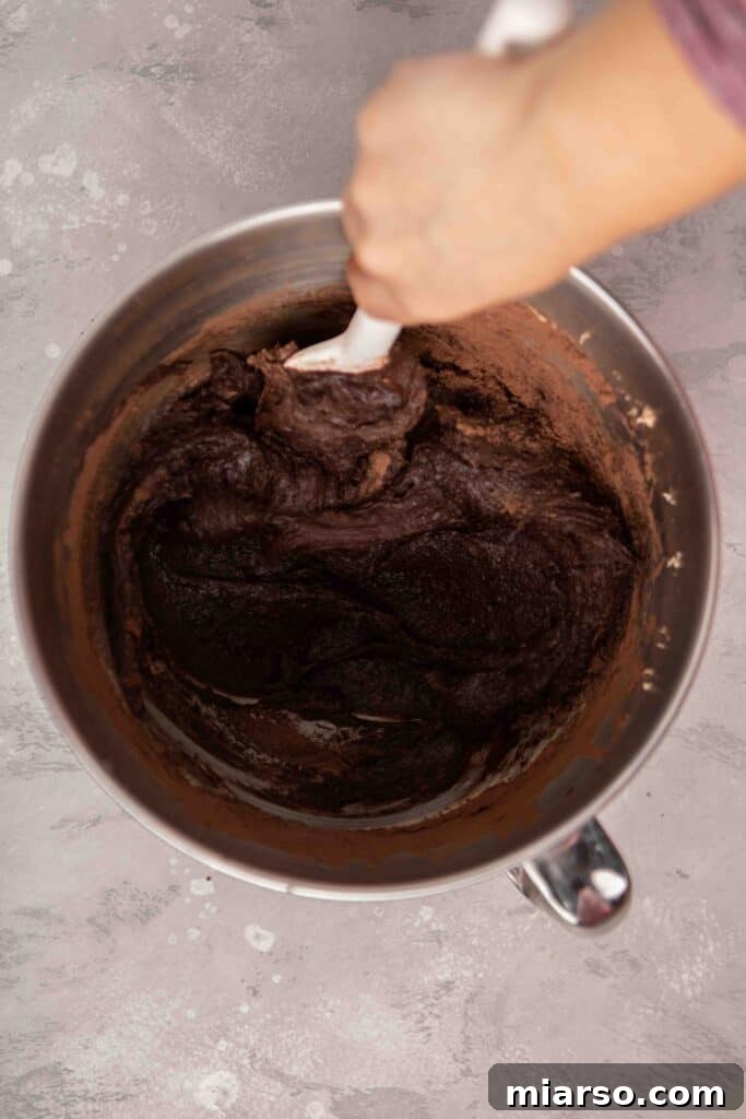 Folding the dry ingredients into the wet ingredients for a perfect brownie batter