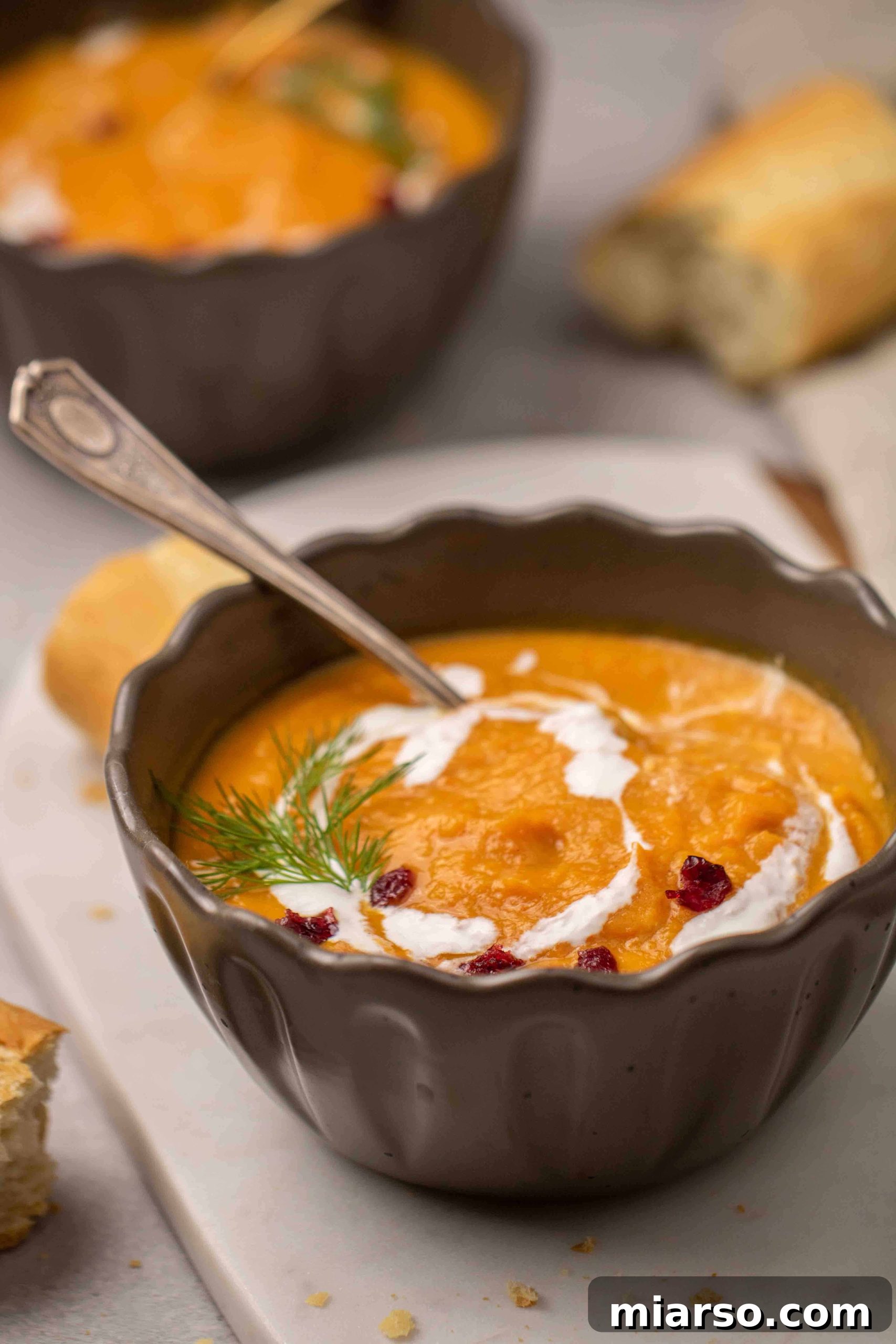 A beautifully presented bowl of creamy carrot and sweet potato soup at a 45-degree angle, ready to be enjoyed.