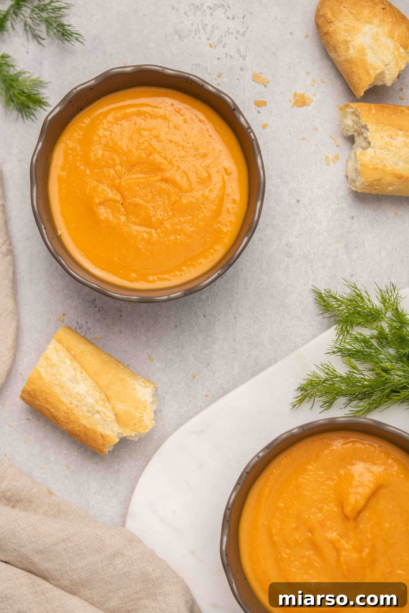 A beautifully garnished bowl of carrot and sweet potato soup, illustrating how to serve it for maximum appeal.
