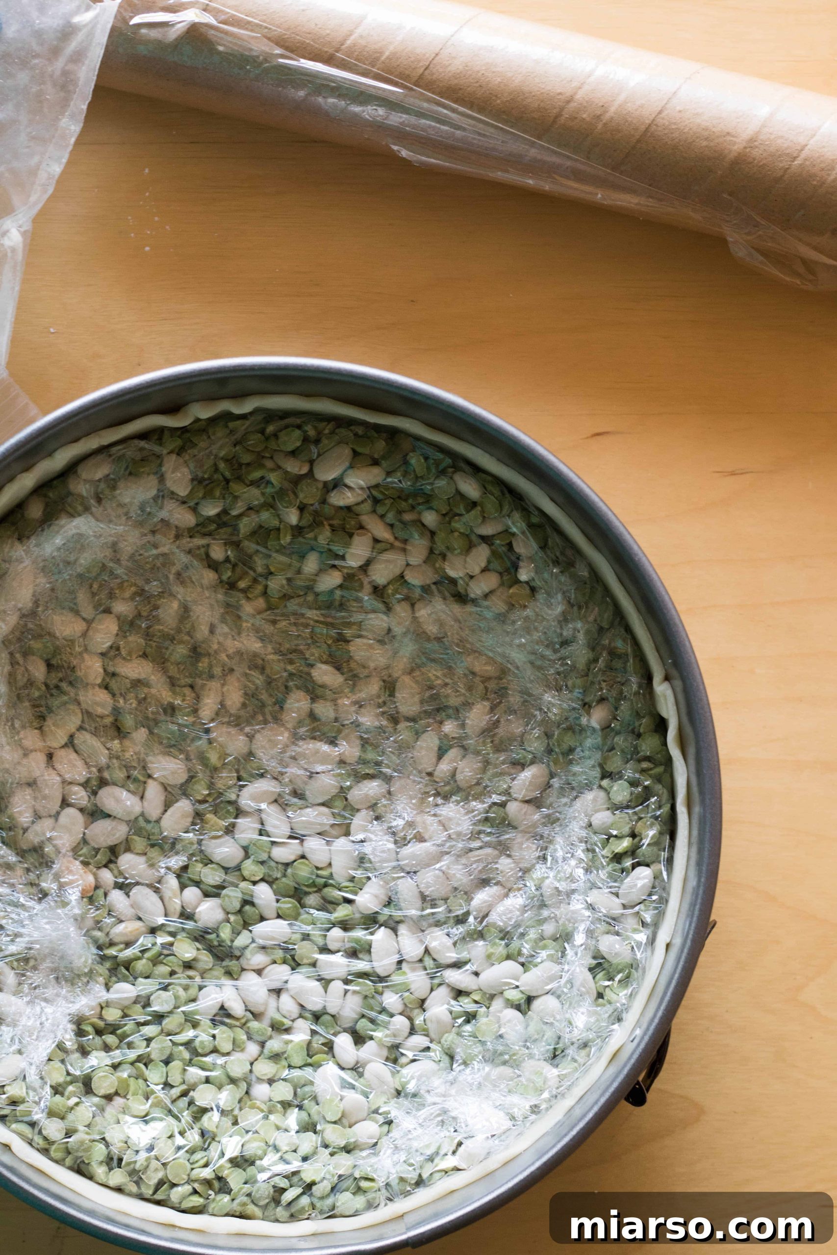 Close-up of pie crust with weights, ready for the oven.