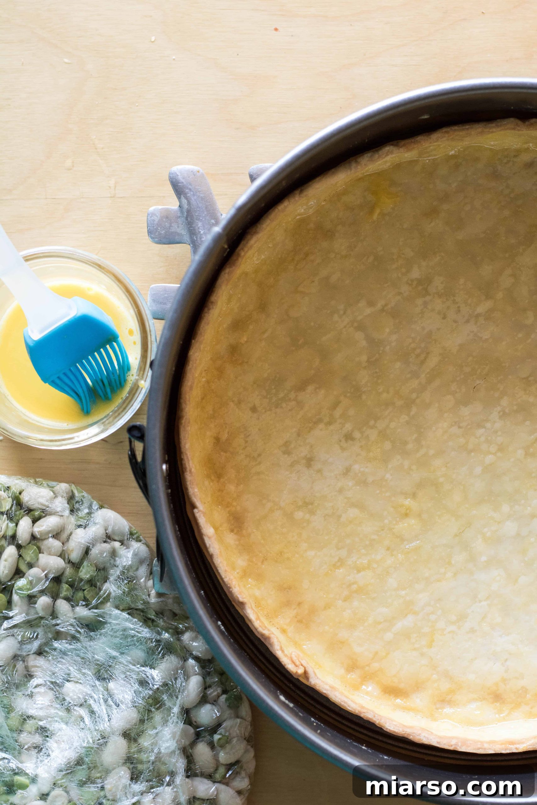 Applying egg wash to a hot, pre-baked pie shell to seal it.