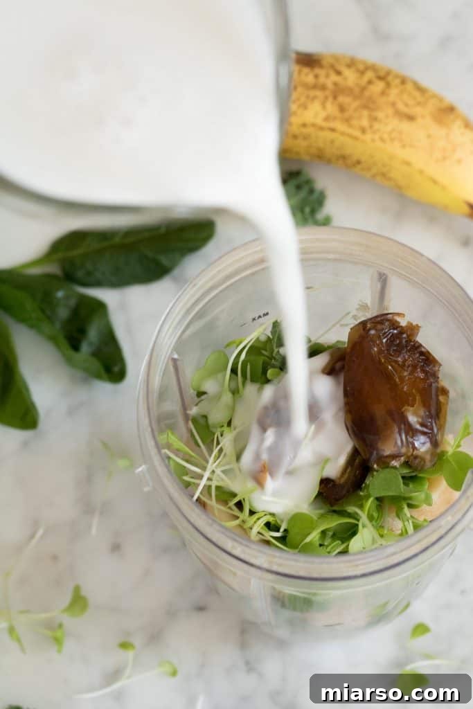 Pouring coconut milk into a blender for a healthy green smoothie