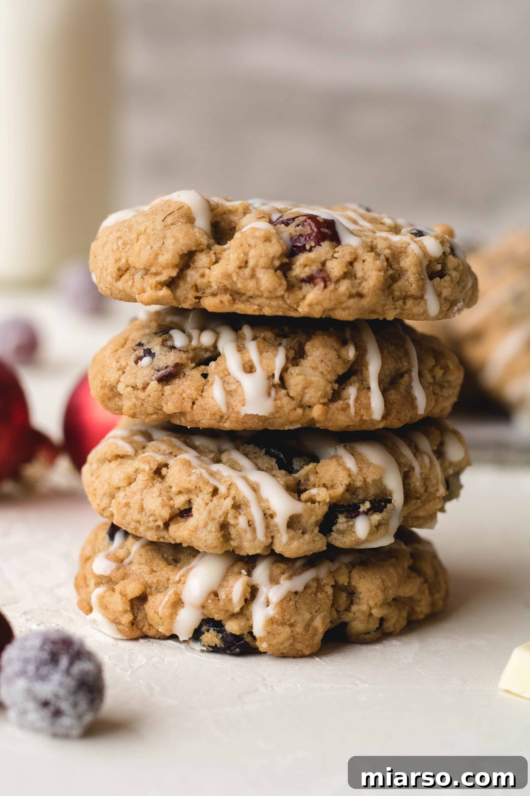 A stack of delicious cranberry oatmeal cookies, drizzled with white chocolate