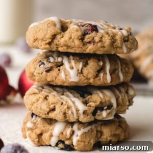 A stack of delicious cranberry oatmeal cookies, drizzled with white chocolate