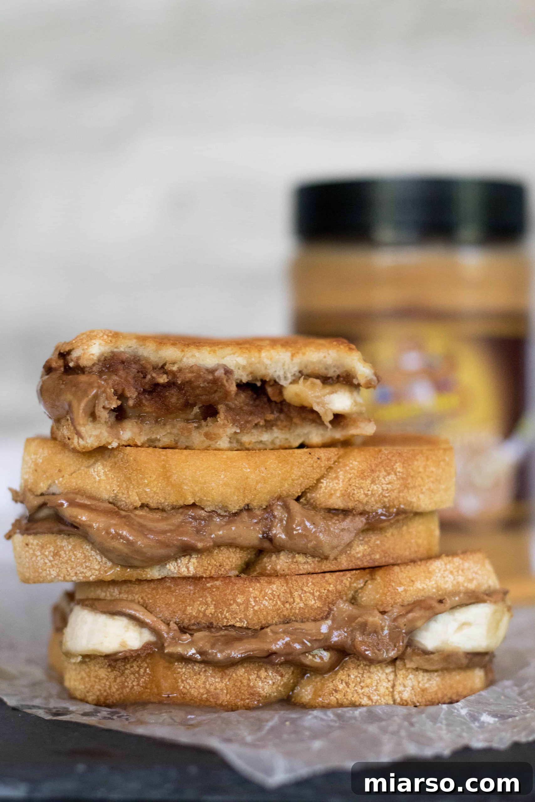 Golden Peanut Butter Banana Melt 3 Izgara fıstık ezmeli muzlu sandviç ikiye kesilmiş, içini gösteriyor