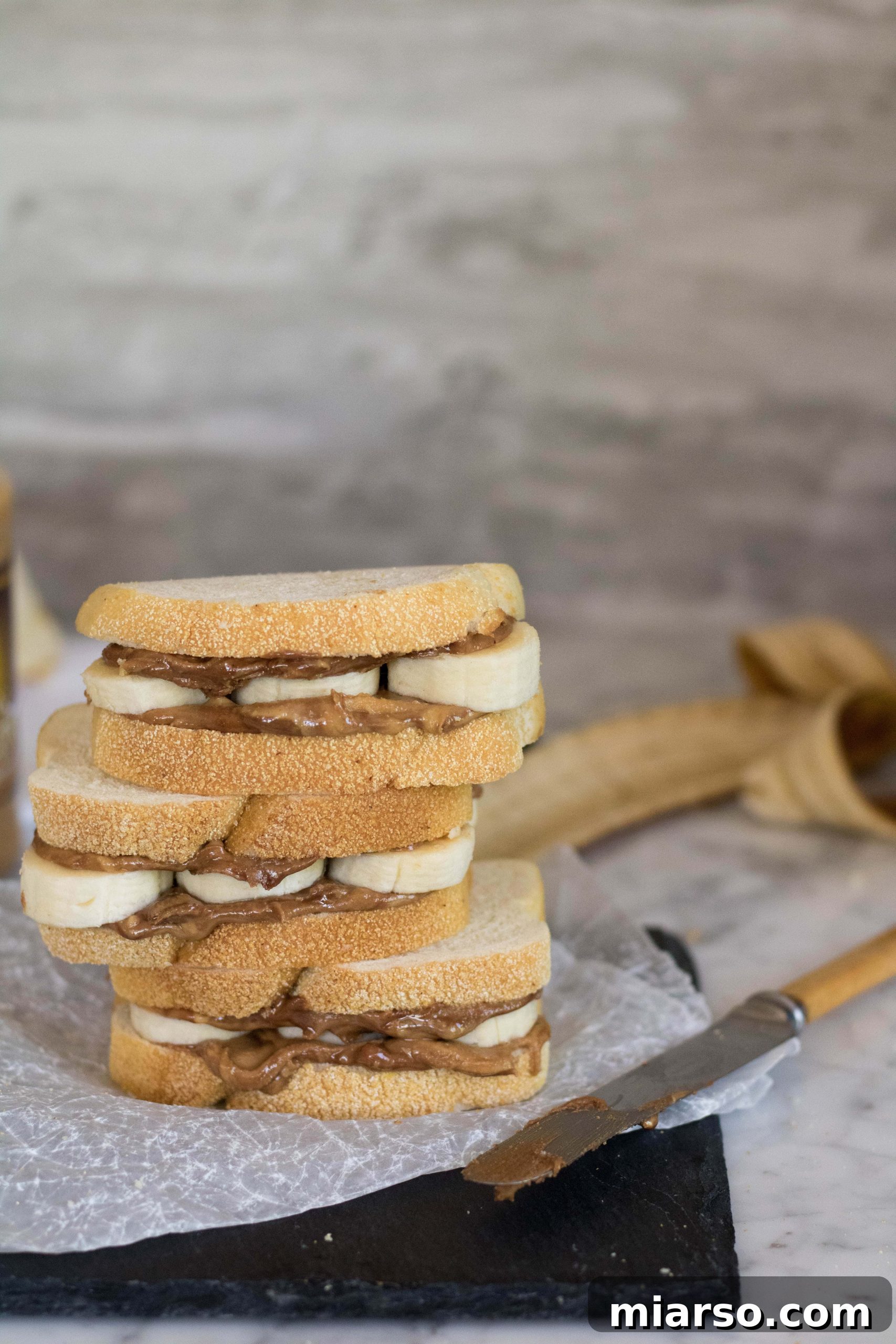 Golden Peanut Butter Banana Melt 5 Izgara fıstık ezmeli muzlu sandviç için malzemeler bir tezgah üzerinde dizili