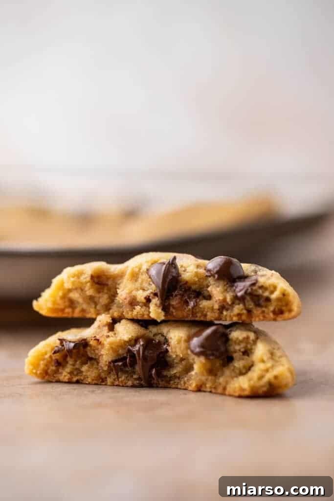 Stack of warm, golden-brown small batch chocolate chip cookies, showcasing their soft texture and abundant chocolate chips.