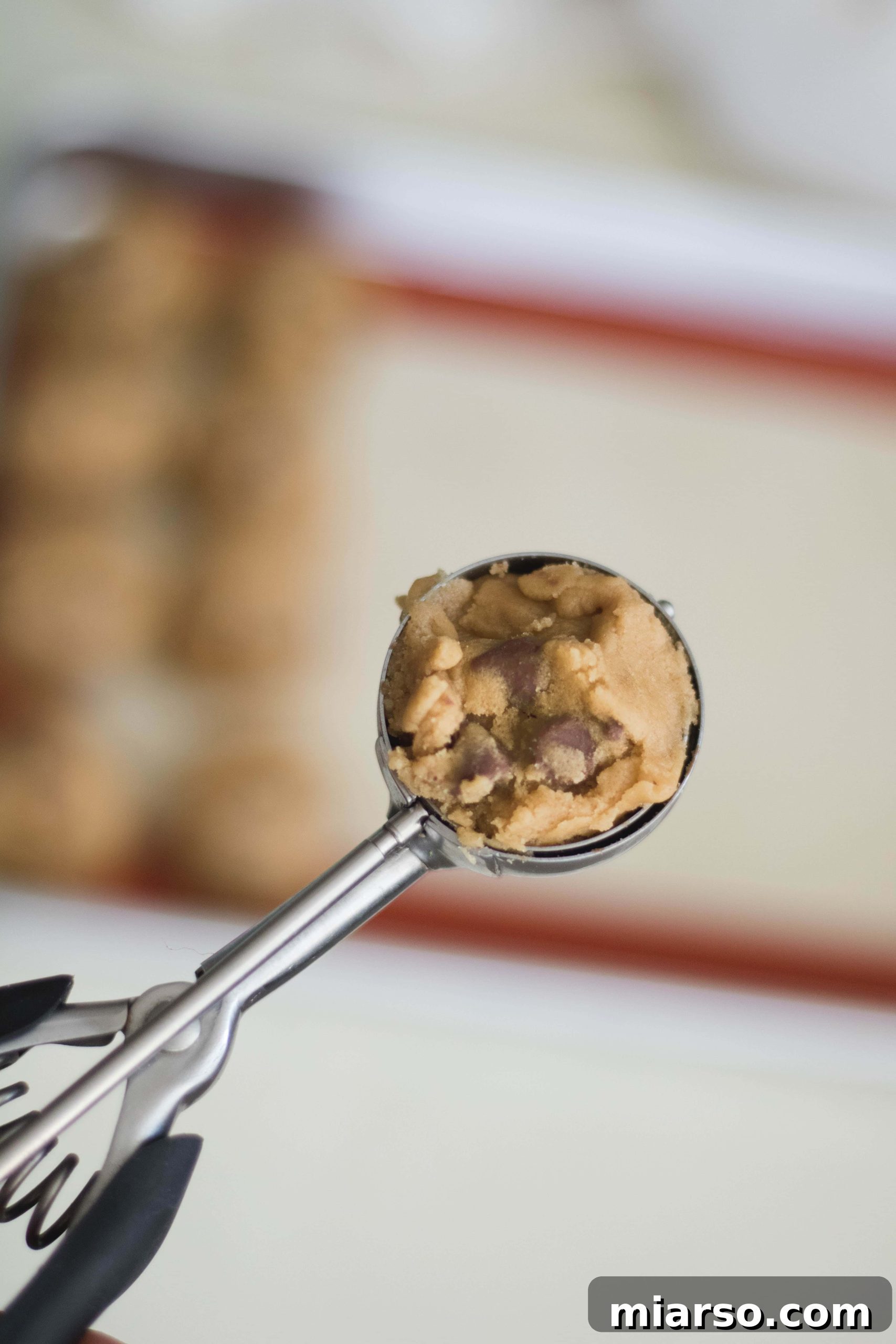 A scoop of chewy and soft chocolate chip cookie dough ready for baking.