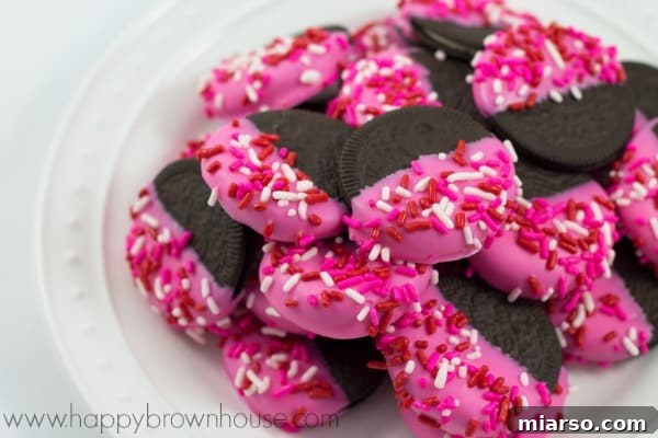 18 Heartfelt No-Bake Valentine Treats Kids Will Adore 11 Valentine's Day Oreos, decorated with pink and red frosting and sprinkles, individually wrapped for gifting.
