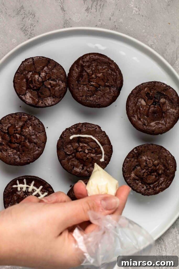 Touchdown Fudgy Brownie Bites 13 Carefully decorating the brownie bites with white chocolate laces to resemble footballs