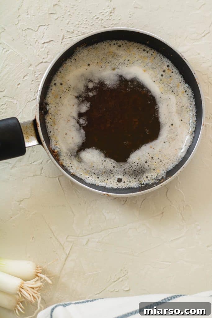 Butter actively browning in a saucepan, showing golden color.