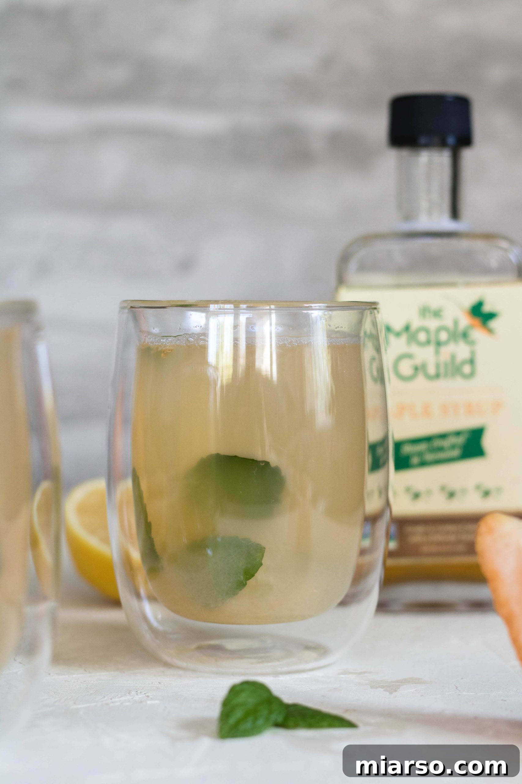 Delicious warm grapefruit detox tea in a clear mug, garnished with mint and grapefruit slices
