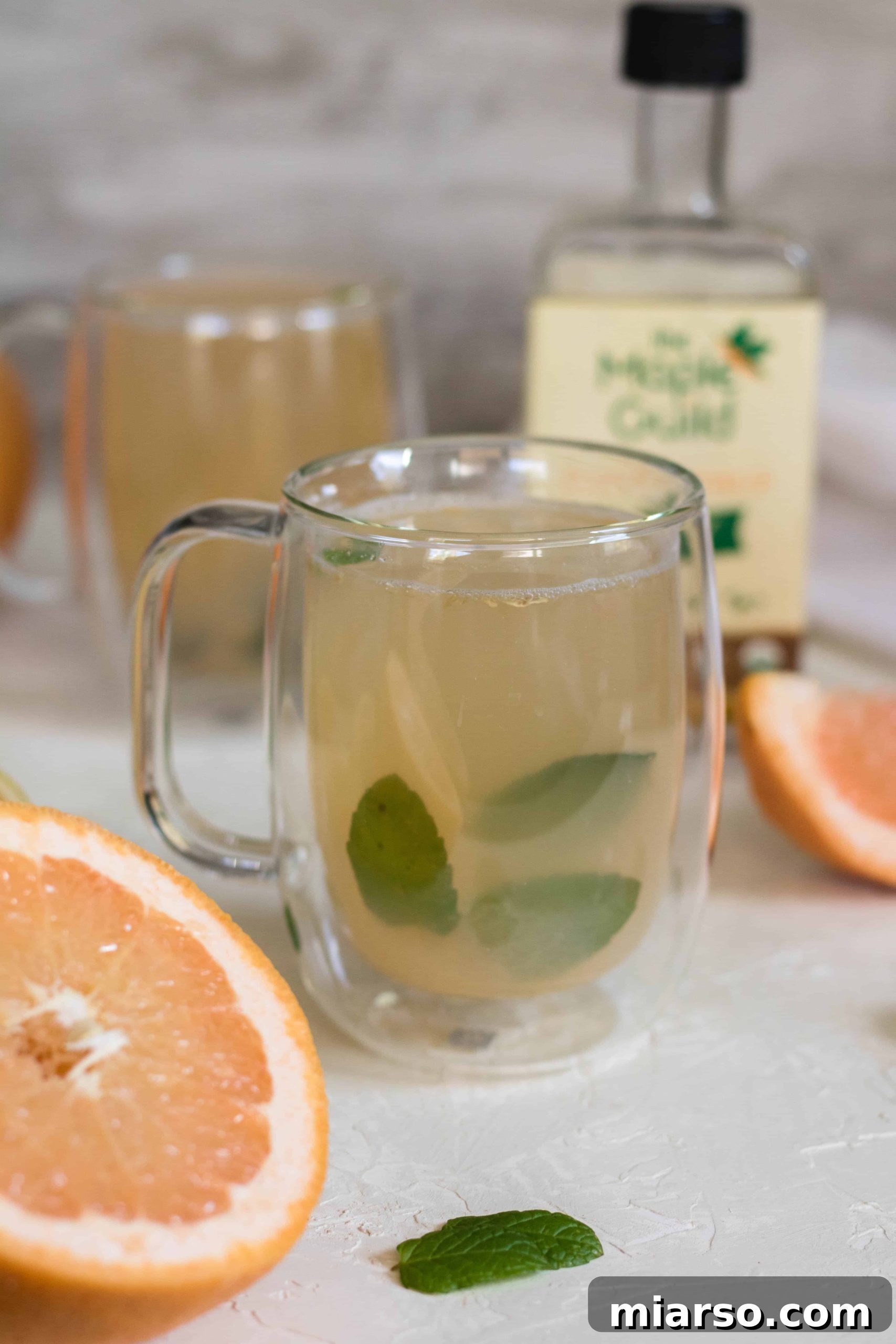 Close-up of a warm mint grapefruit detox tea in a clear double-walled mug, ready to be enjoyed