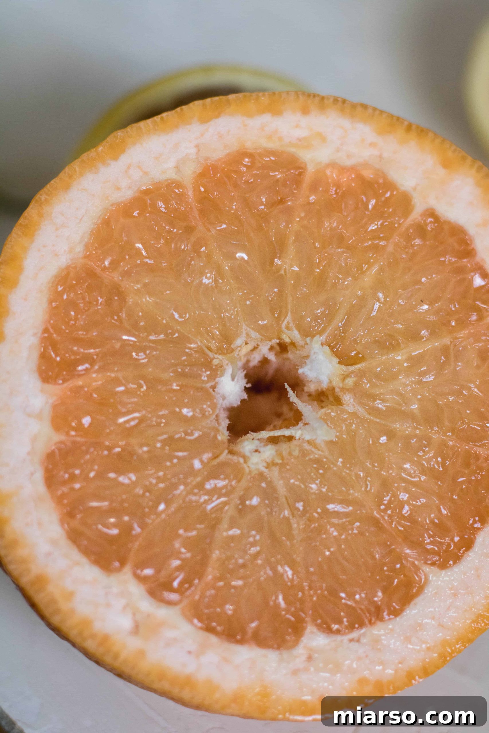 Close-up of a perfectly sliced open grapefruit, revealing its juicy segments