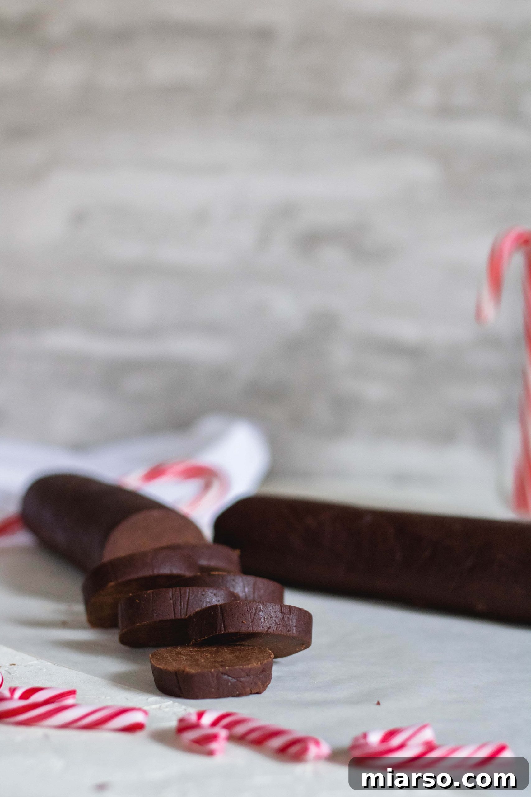 Gourmet Chocolate Peppermint Crunch Logs 7 Chilled cookie dough log being sliced into even cookie rounds