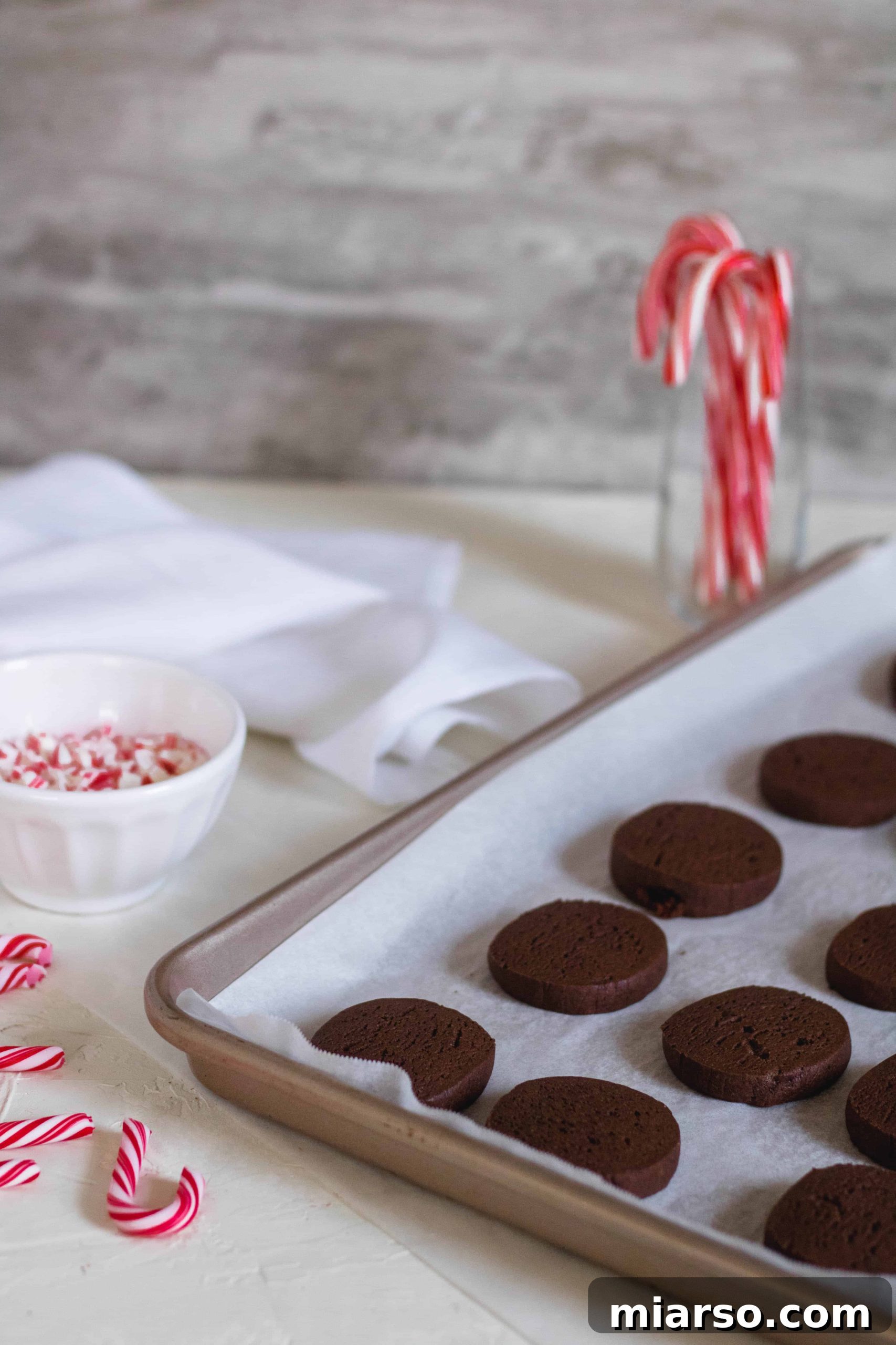 Gourmet Chocolate Peppermint Crunch Logs 8 Chocolate peppermint cookies baking on a parchment-lined baking sheet