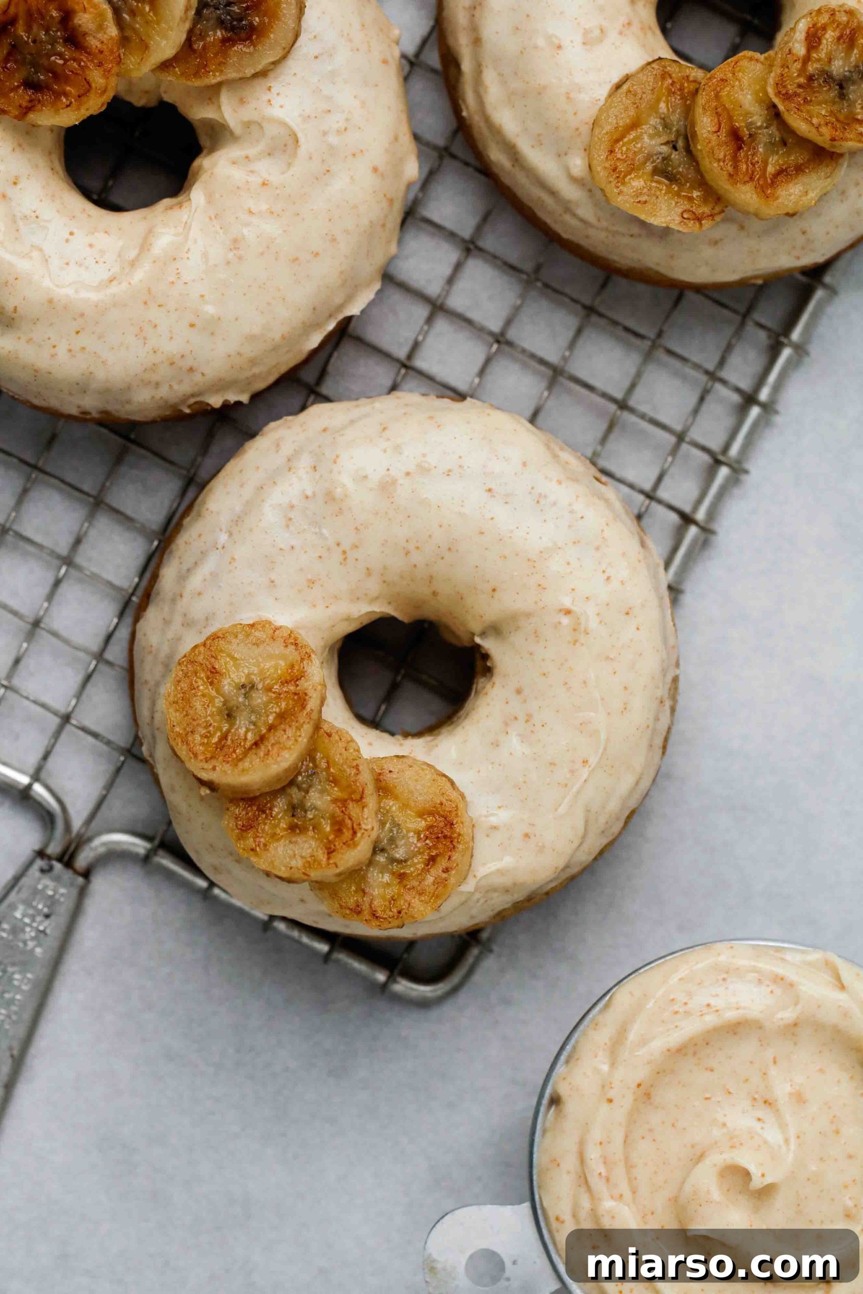 Stack of freshly baked banana donuts with shimmering brown butter glaze on top