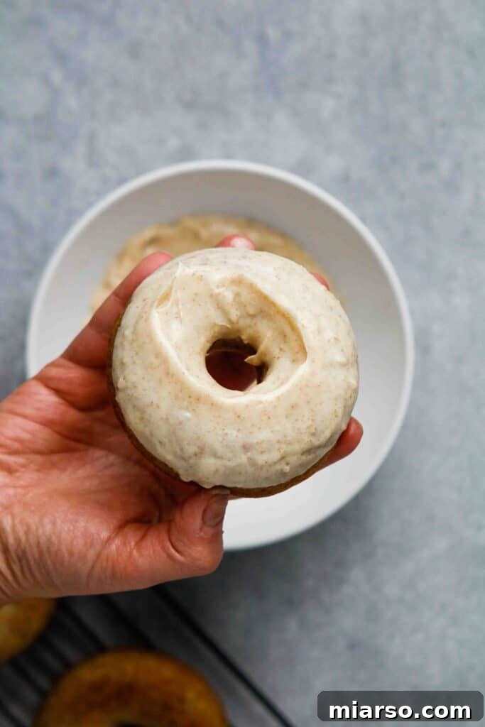 Freshly glazed banana donuts cooling on a wire rack, with the brown butter glaze setting to a beautiful shine.
