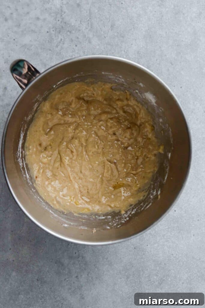 A donut pan filled with banana donut batter, ready to be placed in the oven for baking.